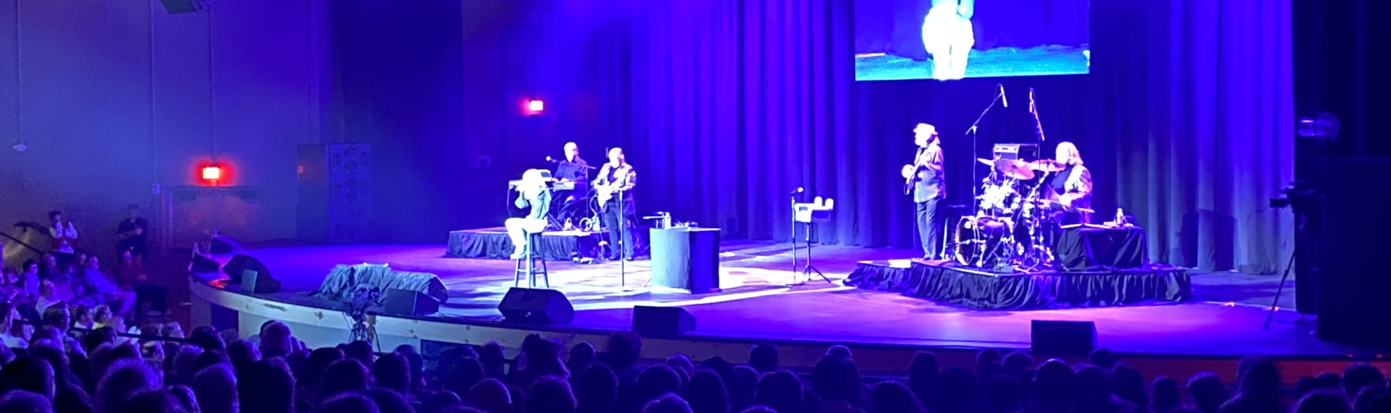 signer on stage in chair washed out by the lights Ann Arbor